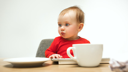 Image showing Happy child baby girl toddler sitting with keyboard of computer isolated on a white background