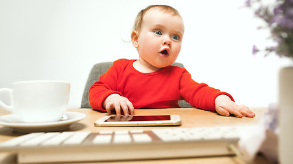 Image showing Happy child baby girl toddler sitting with keyboard of computer isolated on a white background