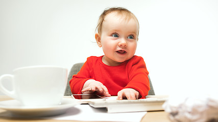 Image showing Happy child baby girl toddler sitting with keyboard of computer isolated on a white background