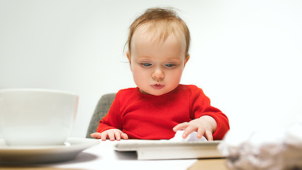 Image showing Happy child baby girl toddler sitting with keyboard of computer isolated on a white background