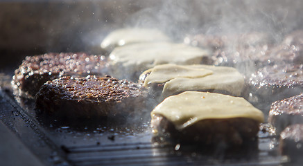 Image showing Preparing burgers at the barbecue outdoors