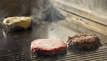 Image showing Preparing burgers at the barbecue outdoors