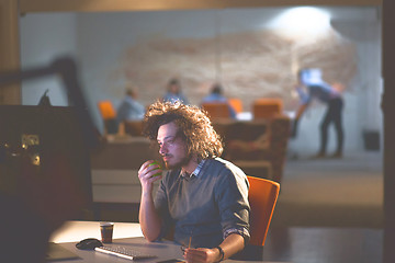 Image showing man working on computer in dark office