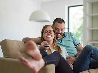 Image showing Young couple on the sofa watching television