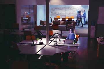 Image showing man working on computer in dark office