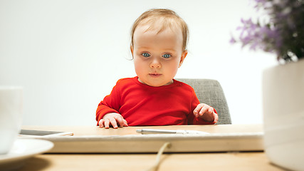 Image showing Happy child baby girl toddler sitting with keyboard of computer isolated on a white background