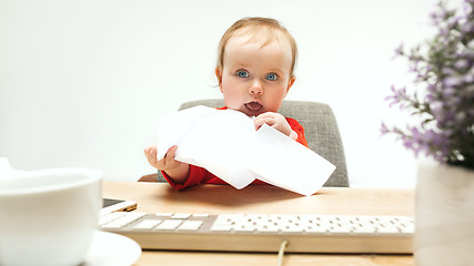 Image showing Happy child baby girl toddler sitting with keyboard of computer isolated on a white background