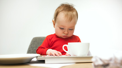 Image showing Happy child baby girl toddler sitting with keyboard of computer isolated on a white background