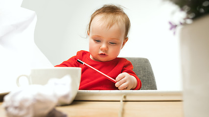 Image showing Happy child baby girl toddler sitting with keyboard of computer isolated on a white background