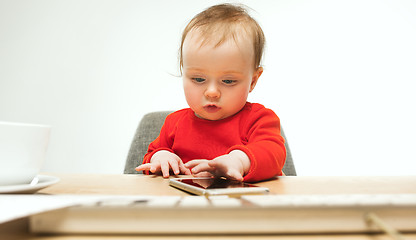 Image showing Happy child baby girl toddler sitting with keyboard of computer isolated on a white background