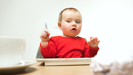 Image showing Happy child baby girl toddler sitting with keyboard of computer isolated on a white background