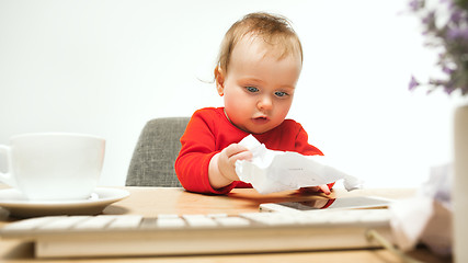 Image showing Happy child baby girl toddler sitting with keyboard of computer isolated on a white background