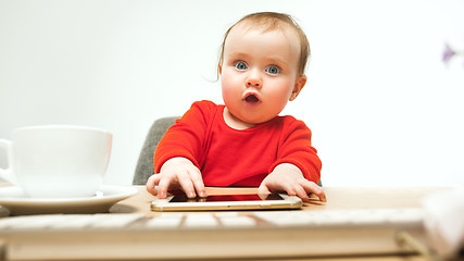 Image showing Happy child baby girl toddler sitting with keyboard of computer isolated on a white background