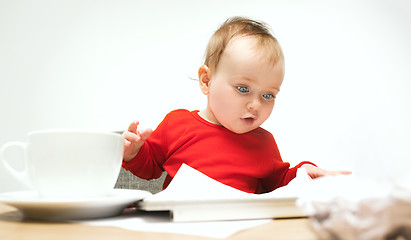 Image showing Happy child baby girl toddler sitting with keyboard of computer isolated on a white background