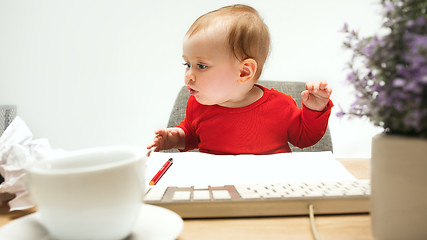 Image showing Happy child baby girl toddler sitting with keyboard of computer isolated on a white background