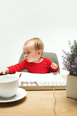 Image showing Happy child baby girl toddler sitting with keyboard of computer isolated on a white background