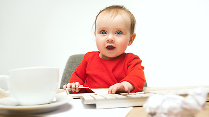 Image showing Happy child baby girl toddler sitting with keyboard of computer isolated on a white background