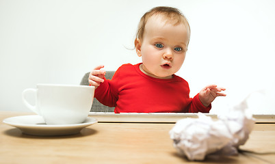 Image showing Happy child baby girl toddler sitting with keyboard of computer isolated on a white background