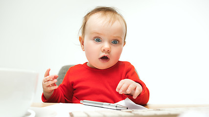 Image showing Happy child baby girl toddler sitting with keyboard of computer isolated on a white background