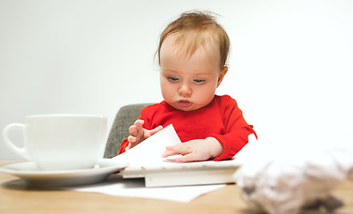 Image showing Happy child baby girl toddler sitting with keyboard of computer isolated on a white background