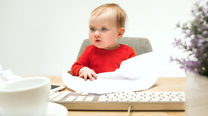 Image showing Happy child baby girl toddler sitting with keyboard of computer isolated on a white background