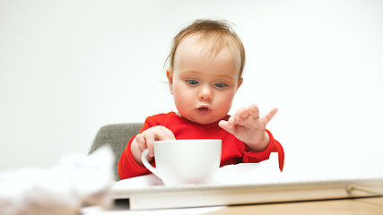 Image showing Happy child baby girl toddler sitting with keyboard of computer isolated on a white background