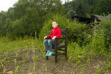 Image showing Boy Sitting on Chair in the Forest