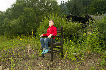 Image showing Boy Sitting on Chair in the Forest