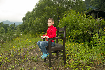 Image showing Boy Sitting on Chair in the Forest