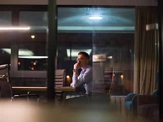 Image showing man working on laptop in dark office