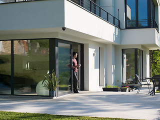 Image showing man drinking coffee in front of her luxury home villa