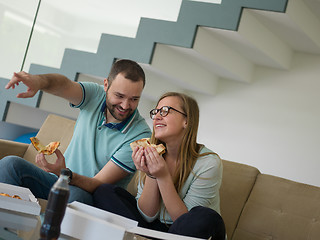 Image showing couple eating pizza in their luxury home villa