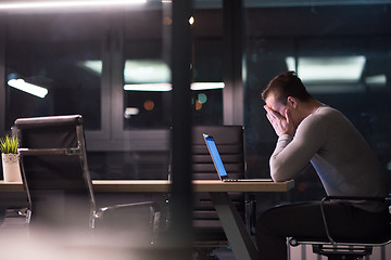 Image showing man working on laptop in dark office