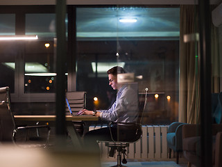 Image showing man working on laptop in dark office