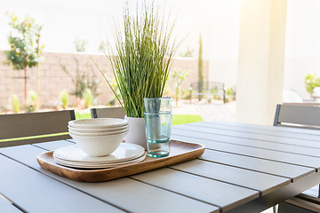 Image showing Outdoor Patio Setting with Dishes and Glasses on Tray