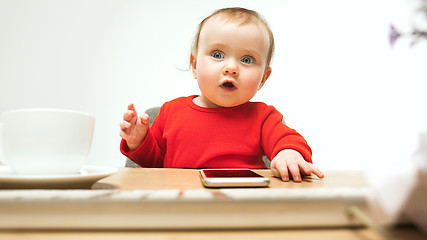 Image showing Happy child baby girl toddler sitting with keyboard of computer isolated on a white background