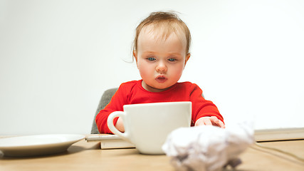 Image showing Happy child baby girl toddler sitting with keyboard of computer isolated on a white background
