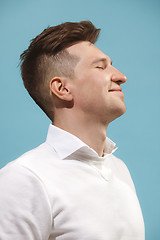 Image showing The happy business man standing and smiling against studio background.