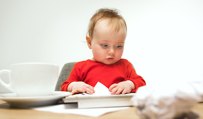 Image showing Happy child baby girl toddler sitting with keyboard of computer isolated on a white background