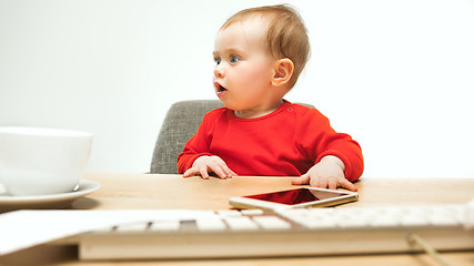 Image showing Happy child baby girl toddler sitting with keyboard of computer isolated on a white background