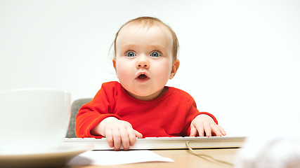 Image showing Happy child baby girl toddler sitting with keyboard of computer isolated on a white background