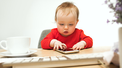 Image showing Happy child baby girl toddler sitting with keyboard of computer isolated on a white background