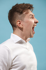 Image showing Isolated on pink young casual man shouting at studio