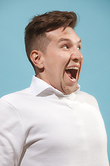 Image showing The happy business man standing and smiling against studio background.