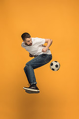 Image showing The young man as soccer football player kicking the ball at studio