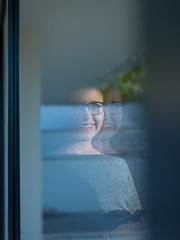 Image showing Woman using tablet at home by the window