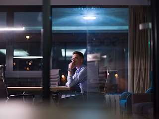 Image showing man working on laptop in dark office