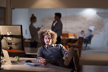 Image showing businessman sitting with legs on desk at office