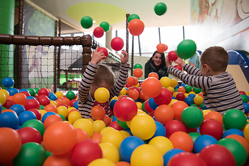 Image showing Young mom with her kids in a children\'s playroom