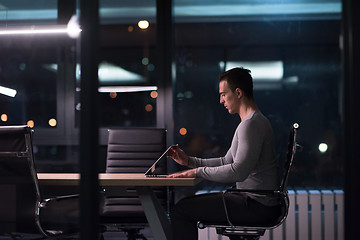 Image showing man working on laptop in dark office